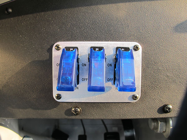 Three toggle switches, under plastic covers to prevent accidentally turning them on.