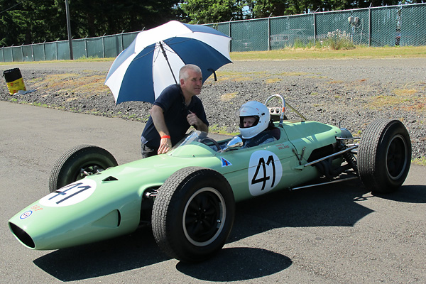 Byron Sanborn holds an umbrella for Kurt DelBene as the pre-grid fills.