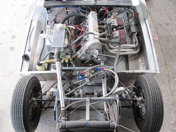 Rearward halves of Elva MkIV two-piece upper control arms are anchored to rubber frame mounts.
