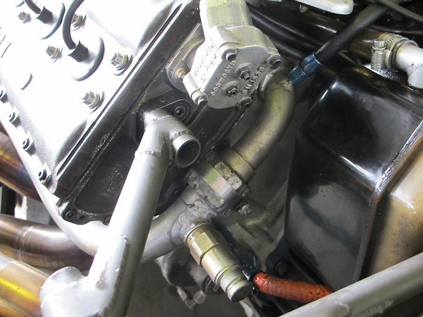 Water flows around the engine to the radiator through hard tubing.