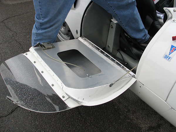 The open door exposes one of the two rear suspension attachment brackets, cantilevered off the frame.