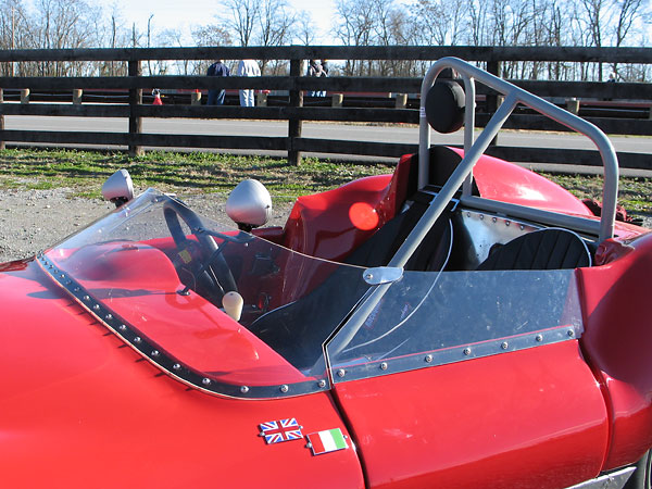 A one piece molded perspex (acrylic) windscreen with matching side screens mounted on the doors.